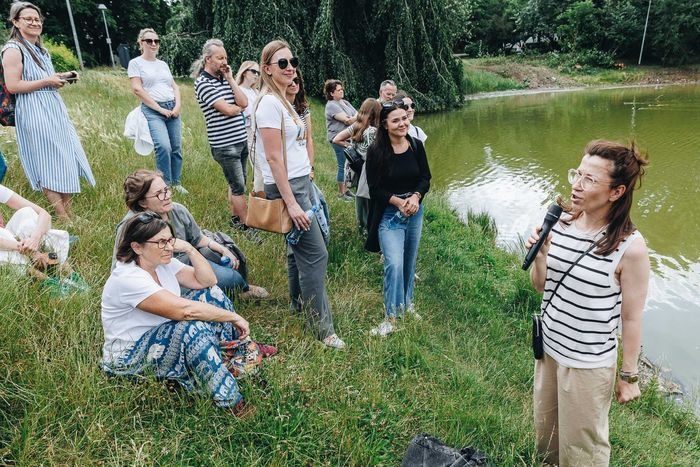 grupa osób nad stawem
